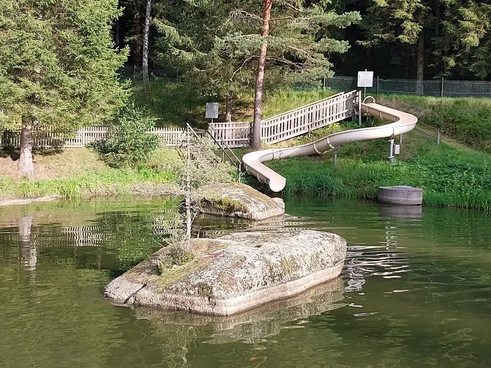 Wasserrutsche, Holzsteg und Granitfelsen am Waldbadteich